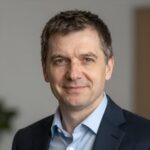 Портрет уверенного бизнесмена компании C-Ap на нейтральном фоне в студийном освещении